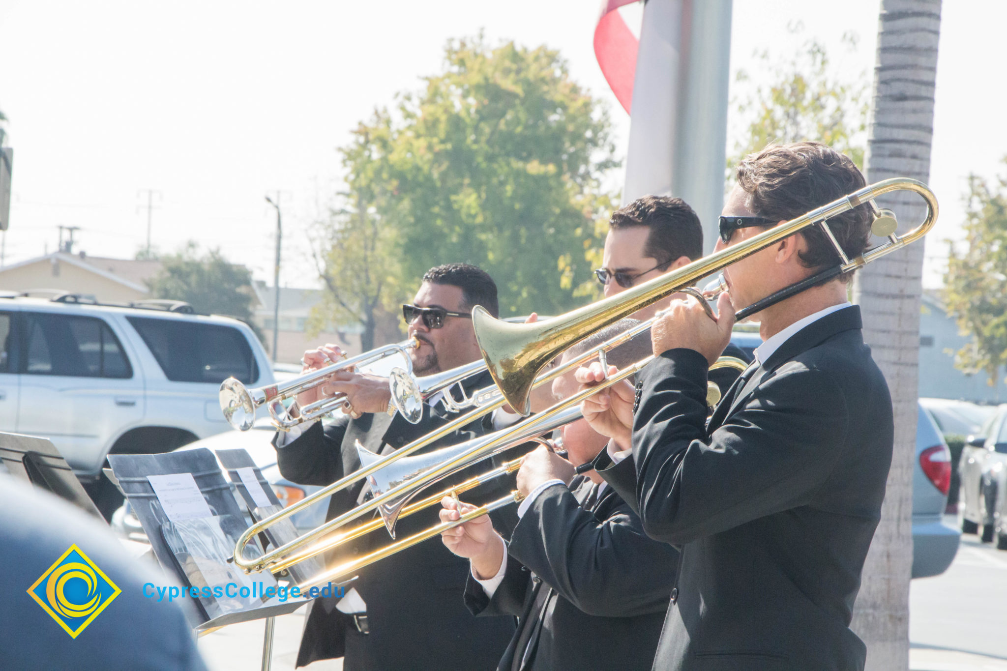 Music instructor Gary Gopar playing the trumpet with two other men.