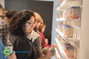 Students looking at pottery on display.