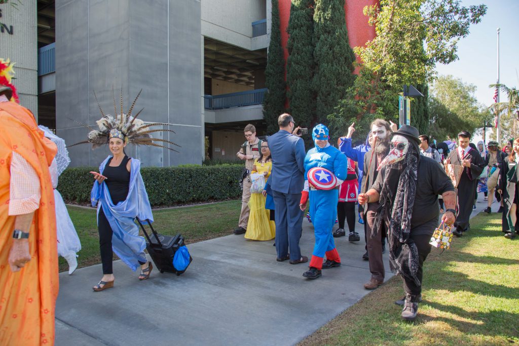 Students dressed up in costume for the 2018 Halloween Parade, walking on campus.