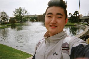 Student smiling by the pond.