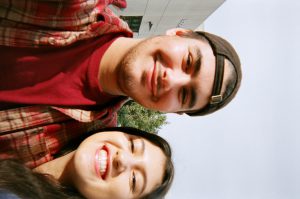 Sideways photo of young man and young woman smiling.