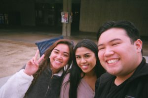 Two women and a young man smiling.