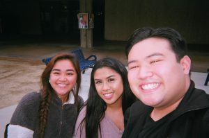 Two women and a young man smiling.