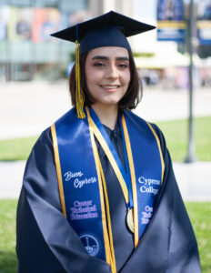 Portrait of Sabrina Tosti, the 2023 Presidential Scholar of Distinction for the CTE pathway, wearing regalia with Gateway Plaza in the background.