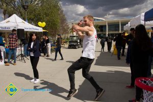 Students gathered at Club Rush event with male student dancing