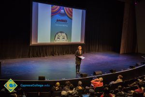 Dr. JoAnna Schilling speaking to an audience in the theater.