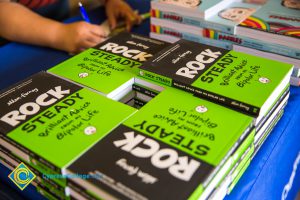 A stack of Ellen Forney books "Rock Steady" on a table.