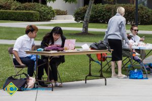 Students sit at tables at stress-relieving event.