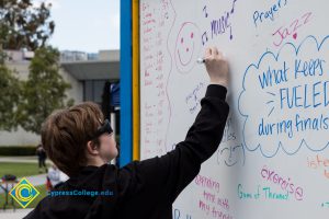 A whiteboard records student thoughts at a stress-relieving event.