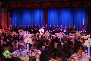 Guest of 39th Annual Americana Awards sitting at banquet tables with group of awardees on stage.