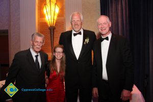 Men in tuxedos with woman at black-tie event