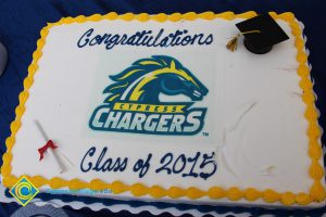 A cake decorated with the Charger logo, cap and scroll with "Congratulations Class of 2015."