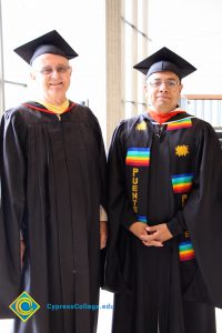 Two gentlemen in graduation regalia.