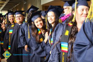 A group of Puente student smiling in their cap and gown.