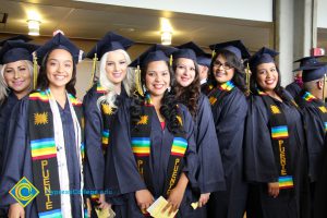 A group of Puente student smiling in their cap and gown.