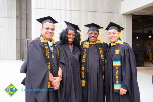 Legacy and Puente staff in graduation regalia during the 48th Commencement.