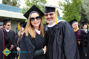 Phil Dykstra with a woman with long brown hair in cap and gown.