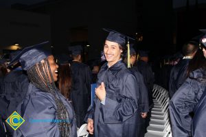 Graduates in their cap and gown, smiling after commencement.