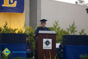 A young man in cap and gown speaking during the 48th Commencement.