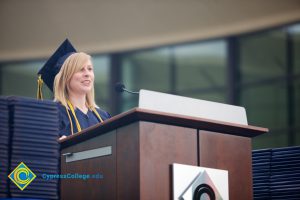 A young woman in cap and gown speaking during the 48th Commencement.