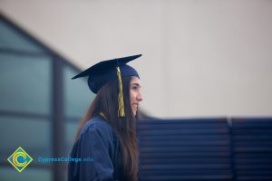 A smiling young woman in cap and gown during 48th Commencement.