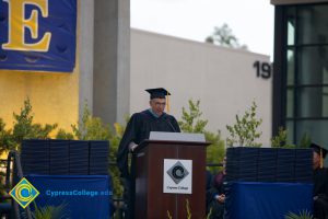 A speaker in cap and gown at 48th Commencement.