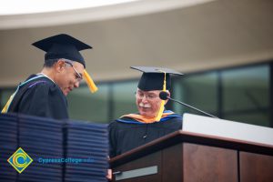 Two men on stage during 48th Commencement.