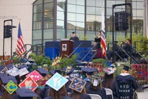 Seated graduates and a speaker on stage during the 48th Commencement.