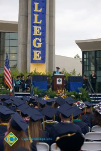 Seated graduates and a speaker on stage during the 48th Commencement.