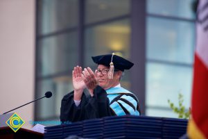 President Bob Simpson smiling and applauding during the 48th Commencement.