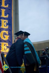 President Bob Simpson embraces a woman during the 48th Commencement.