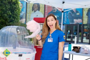 Young lady in a blue shirt holding cotton candy.