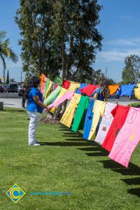 A woman looks at t-shirts hanging on a line for Sexual Assault Awareness Month.