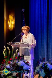 President, JoAnna Schilling speaking on stage.