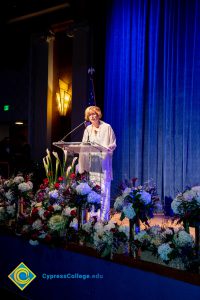 President, JoAnna Schilling speaking on stage.