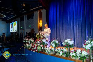 President, JoAnna Schilling speaking on stage.