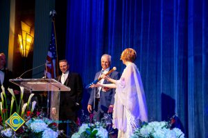 Dr. JoAnna Schilling presenting Brad Pickler with a baseball bat.