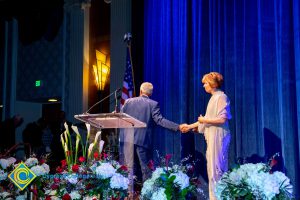 Brad Pickler and Dr. JoAnna Schilling shaking hands on stage.