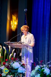 President, JoAnna Schilling speaking on stage.