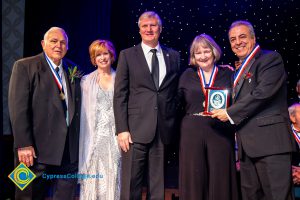 Dr. JoAnna Schilling on stage with three men and a woman wearing black.