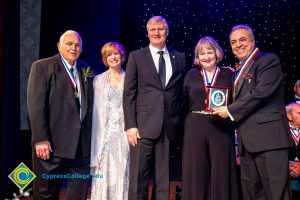 Dr. JoAnna Schilling on stage with three men and a woman wearing black.