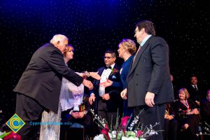 Men and women on stage receiving awards.