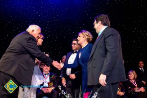 Men and women on stage receiving awards.