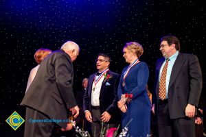 Men and women on stage receiving awards.