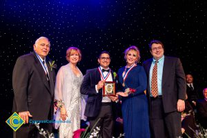 JoAnna Schilling standing on stage with award recipients.