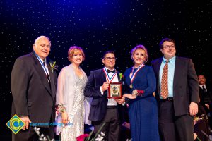 JoAnna Schilling standing on stage with award recipients.