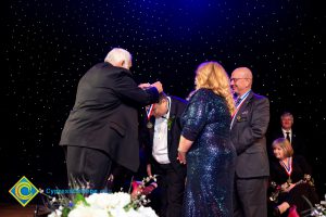 Man receiving an award medal while others look on.