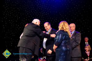 Man receiving an award medal while others look on.