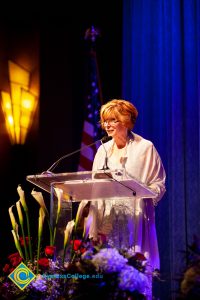 President, JoAnna Schilling speaking on stage.