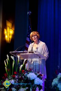 President, JoAnna Schilling speaking on stage.